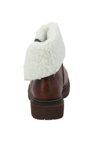 Brun läderankelboot med vit, fluffig krage, texturerad gummisula och förstärkt söm längs botten.