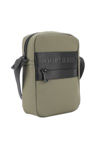 Borsa verde oliva con una fascia nera texture su cui è impresso "JOOP! JEANS". Forma arrotondata con chiusura a zip e tracolla nera regolabile.