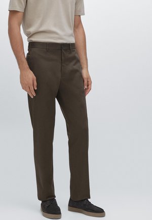 Brown chinos with a straight leg design, made from woven fabric. Features a button closure and side pockets. Worn with dark footwear.