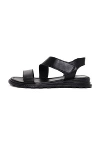 Sandali in pelle nera con cinturini incrociati, punta aperta e suola strutturata. Presentano un tacco basso e una costruzione flessibile per il massimo del comfort.