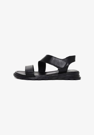 Zwarte leren sandalen met kruisbanden, een open teen en een gestructureerde zool. Bevat een lage hak en een flexibele constructie voor comfort.