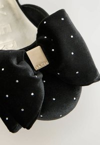 Must musta ballet kingad musta sametiga, millel on suur pael, mis on kaunistatud väikeste rhinestone'idega ja metallise ruudukujulise kaunistusega.