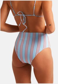 Parte de abajo de bikini de talle alto en azul claro con rayas rojas verticales. Presenta tirantes finos atados en la parte posterior. Material suave y elástico.