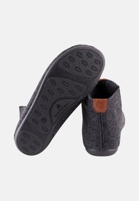 Donkergrijze vilten slippers met rubberen zolen, voorzien van een kleine leren accent in bruin aan de achterkant en een eenvoudig instapontwerp. Zachte textuur.