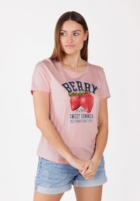 T-shirt en coton rose avec un graphique de deux fraises et le texte "BERRY CLUB SWEET SUMMER CALIFORNIA SINCE 1970". Manches courtes.