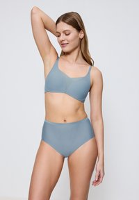 Lichtblauw lingeriesetje met een draadloze bh met verstelbare bandjes en een hoogtaille slip, beide gemaakt van een soepele, elastische stof.