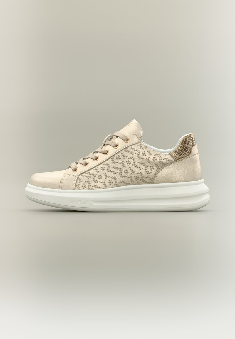 Beige sneakers with logo pattern, smooth leather and textile upper, padded collar, and a thick white rubber sole. Laces and gold accents visible.