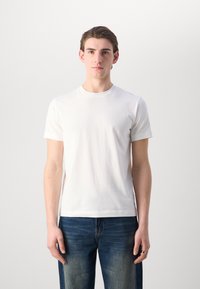Hvid kortærmet T-shirt lavet af blød bomuld, med rund halsudskæring, regular fit og glat tekstur, parret med blå denimjeans.