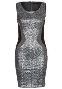 Klänningen har en figurnära silhuett med en grå tygsida och en glittrande silverfärgad paljetfront. Den har ett runt halsringning och dragkedja bak.