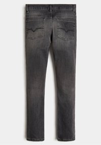 Tummanharmaat farkut, joissa on kapea malli, takataskut, joissa on kulmikkaat ompeleet, ja sileä rakenne.