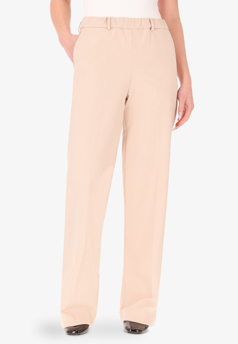 Pantaloni beige a gamba larga realizzati in un tessuto morbido, con un davanti piatto, due tasche laterali e una vestibilità rilassata, adatti per un abbigliamento casual o formale.