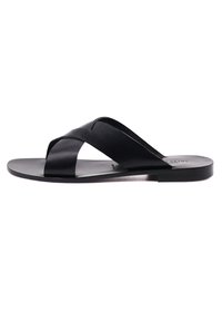 Infradito nere con cinturini incrociati in pelle liscia, design minimalista e suola piatta per un facile utilizzo.