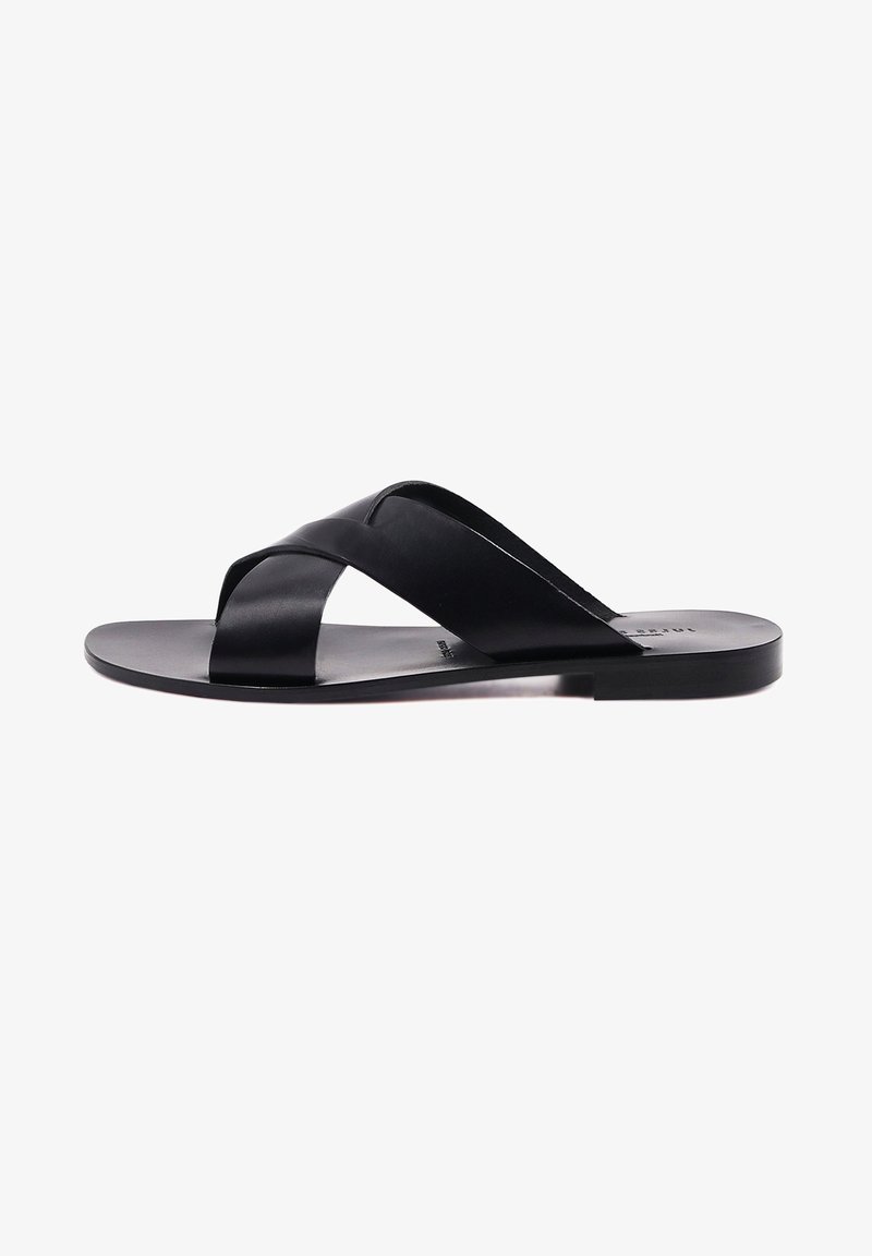 Infradito nere con cinturini incrociati in pelle liscia, design minimalista e suola piatta per un facile utilizzo.