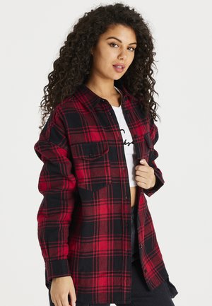 Czerwono-czarna koszula flanelowa w kratę z długimi rękawami, zapinana na guziki, z dwiema kieszeniami na piersiach i lekko luźnym krojem.