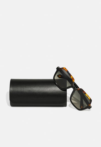 Sonnenbrille mit rechteckigen, dunklen Gläsern, schwarzem und schildpattfarbenem Gestell, das auf einem schwarzen Lederetui liegt, das mit "Emporio Armani" geprägt ist.