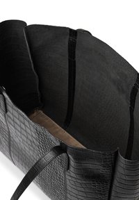 Svart läder tote-väska med ett texturerat krokodilmönster och ett rymligt inre som är klätt med en slät beige tyg.