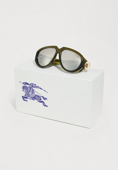 Υπερμεγέθη, σκούρα πράσινα γυαλιά ηλίου με σκουρόχρωμους φακούς. Διαθέτουν χρυσούς μεταλλικούς μεντεσέδες στους βραχίονες. Συνοδεύονται από λευκό κουτί με μπλε λογότυπο αλόγου.