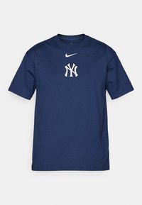 Námornícky modré bavlnené tričko s bielym logom Nike nad bielym a modrým logom New York Yankees na hrudi. Klasický dizajn s okrúhlym výstrihom.