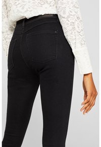 Jeans skinny negros con un diseño clásico de cinco bolsillos, fabricados en denim elástico con un acabado suave y con una marca discreta en la cinturilla.