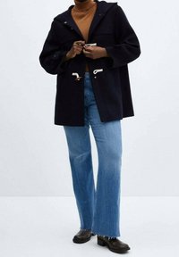Cappotto da marinaio con cappuccio, caratterizzato da chiusure a bottone e dettagli bianchi. Abbina jeans flare azzurri chiari e stivali neri alla caviglia.