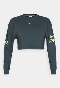 Mørkegrå cropped lang�ærmet sweatshirt lavet af bomuld. Har et hvidt Nike swoosh logo og fed gul "PRO" tekst på venstre ærme.