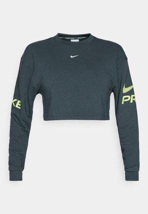 Tumehallist puuvillast lühikese varrukaga sweatshirt. Vasakul varrukal on valge Nike swoosh logo ja julged kollased "PRO" tekst.
