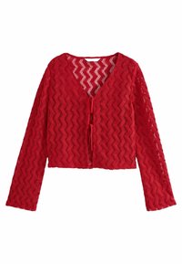 Cardigan court rouge en tissu maille texturé avec un motif en zigzag, présentant un col en V et des manches longues, fermé par un lien à l'avant.