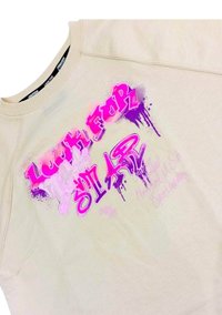 Felpa crema con testo in stile graffiti di un vivace rosa e viola che recita "Cerca la Stella" con dettagli di vernice spray.