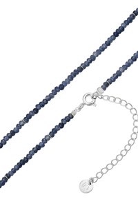 Náhrdelník z korálkov vyrobený z tmavo modrých kameňov so striebornými akcentmi. Obsahuje zapínanie a nastaviteľný reťazec. Guľaté korálky rôznych veľkostí.