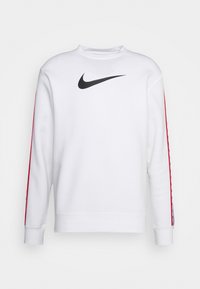 Vit sweatshirt med svart Nike-logotyp på bröstet, röda detaljer längs ärmarna, rund halsringning, långa ärmar, tillverkad av mjukt tyg.