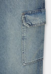 Ljusblå denimtyg med synlig textur; har en stor lapplomme med sömsydda kanter och orange tråddetaljer.