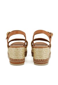 Sandalias de cuña de cuero marrón con detalles de yute trenzado, correas en el tobillo y una plantilla acolchada, que cuentan con una suela texturizada para mayor agarre.