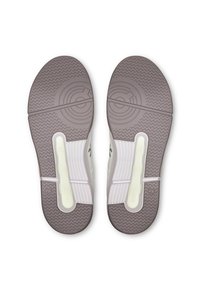 Shoe soles in light beige with textured grip patterns, circular accents, and a segmented design for enhanced flexibility and support.