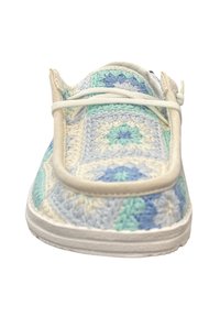 Gehaakte instap schoenen met een patroon van blauwe, groene en crèmekleurige vierkanten, met een witte rubberen zool en beige elastische accenten.