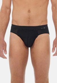 Schwarze Boxershorts aus glattem Stoff. Mit einem breiten elastischen Bund und einer konturierten Tasche für Unterstützung. Klassisches Design.