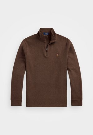 Brun långärmad tröja med dragkedja i kragen, tillverkad av texturerat material, med en liten logotyp på vänster bröst.