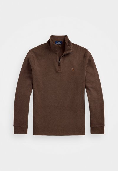 Pull-over marron à manches longues avec un col zippé, fabriqué à partir d'un tissu texturé, présentant un petit logo sur la poitrine gauche.