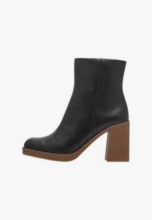 Bottine en cuir noir avec un bout arrondi, un talon en bois carré et une texture lisse. Présente un design sans couture et des lignes épurées.