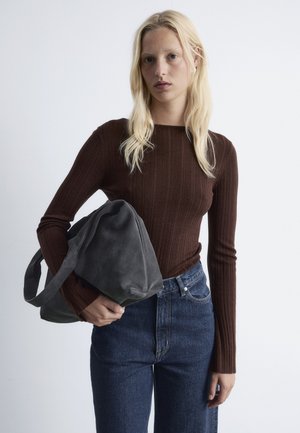 Braunes geripptes Langarmoberteil, hochtaillierte blaue Jeans aus Denim und graue Wildlederumhängetasche. Glatte Textur, lässiges Design, figurbetonte Silhouette.