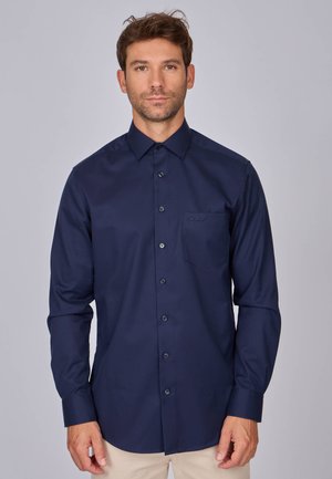Chemise boutonnée à manches longues bleue marine avec un col, une poche avant et des boutons assortis. Tissu lisse avec une silhouette ajustée.