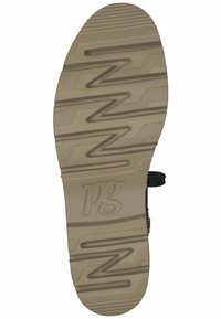 La suela del zapato presenta un dibujo con un patrón en beige, con líneas en zigzag y un logo marcado como "pg". Los bordes son redondeados, lo que proporciona estabilidad y agarre.