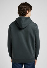 Felpa grigia scura con tessuto texturizzato, tasca a marsupio, cappuccio regolabile con cordino e polsini e orlo a coste. Vista posteriore mostrata.