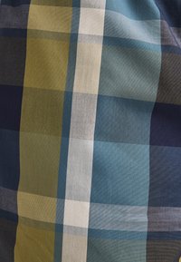 Baumwollstoff mit einem Karomuster aus blauen, grünen und marineblauen Quadraten. Die Textur ist gewebt und zeigt verschiedene Schattierungen und subtile Kontraste.