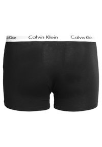 Crne pamučne bokserice s glatkom teksturom, s bijelim elastičnim pojasom s brendom "Calvin Klein". Jednostavan i klasičan dizajn.