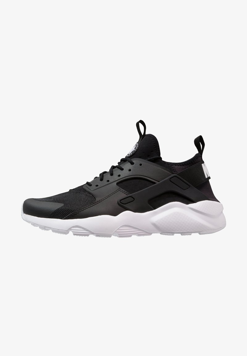 Black athletic shoe with mesh and synthetic materials, white midsole, distinctive heel cutout, and black accent details.