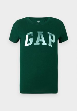 T-shirt in cotone verde con maniche corte e scollo rotondo, caratterizzato da un grande logo argento "GAP" sul davanti. Texture liscia.