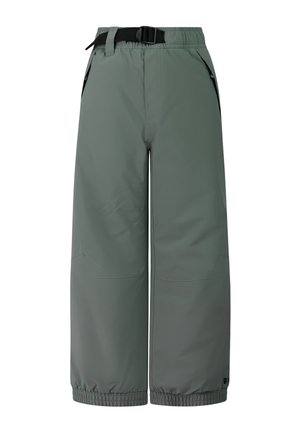 Jongen staande, draagt een grijs zipvest met lange mouwen, losse groene broek en zwarte laarzen tegen een eenvoudige lichte achtergrond.