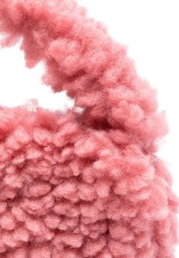 Fluffy roze stoffen handtas met een textuurrijke, bobbly oppervlakte. Korte schouderriem is gemaakt van hetzelfde materiaal, wat zorgt voor een samenhangend ontwerp.