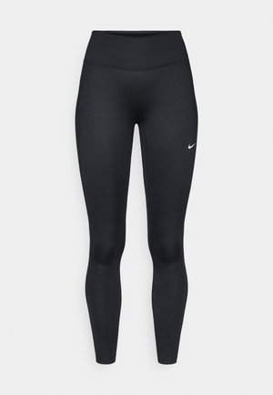 Melni sporta legingi no elastīga materiāla ar augstu vidukļa daļu, uz kreisā augšstilba izvietots neliels balts Nike logotips.