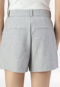 Gray shorts made of textured fabric, featuring a straight cut, belt loops, and two back pockets with a flat finish.